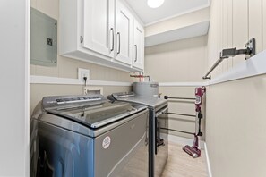 A kitchen with a built-in oven, a water dispenser, and a vacuum cleaner. - Long Bay Dunes E1 - Ocean Front 2 Bed/2 Bath Condo - Pool - 1st Floor Unit (Myrtle Beach)