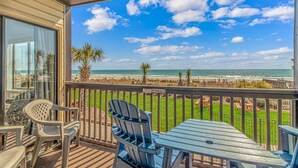 A balcony with a view of the beach, outdoor furniture, and a 'No Smoking' sign. - Long Bay Dunes E1 - Ocean Front 2 Bed/2 Bath Condo - Pool - 1st Floor Unit (Myrtle Beach)