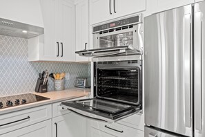 A modern kitchen with stainless steel appliances, including a refrigerator, oven, and microwave. - Long Bay Dunes E1 - Ocean Front 2 Bed/2 Bath Condo - Pool - 1st Floor Unit (Myrtle Beach)