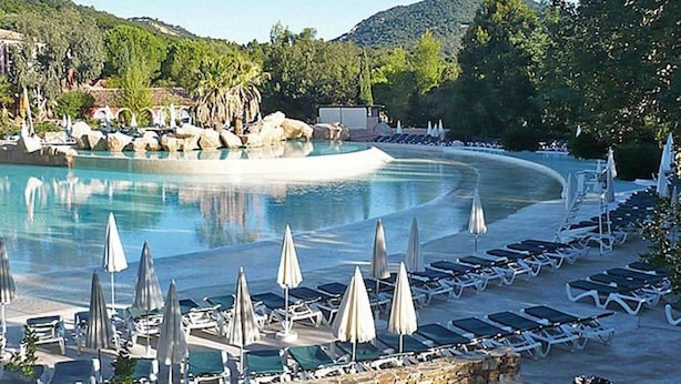 A resort pool with lounge chairs and umbrellas, surrounded by greenery and hills. - Villa 3 bed 2 bath 6 pers, south facing, Golfe St Tropez, air-conditioned, free wifi (Grimaud)