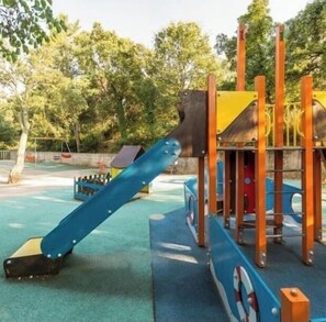 Children can play on the slide and climbing elements in this outdoor playground.