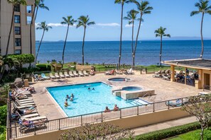 Un espace piscine d’hôtel comprenant plusieurs piscines, des chaises longues et des palmiers.