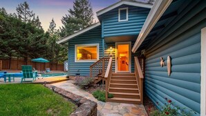 Una casa azul con un camino de piedra que lleva a una escalera de madera.
