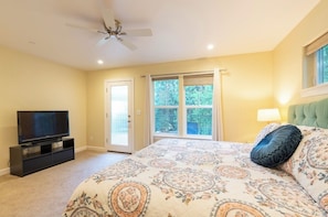 A bedroom with a bed, a television, a ceiling fan, and a window with curtains. - New, Cozy home- walk to downtown! (Nevada City)