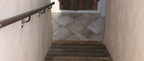 Una escalera de piedra con una puerta de madera al final.