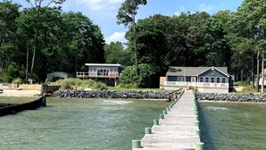 Un muelle de madera que lleva a un muelle con una casa al final.