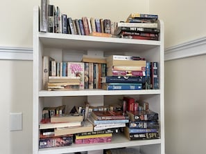 A bookshelf with various books, including titles like 'The Silent Patient' and 'Hit Me!'.