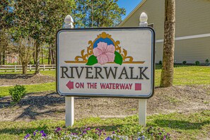 A sign for Riverwalk on the Waterway with directional arrows.