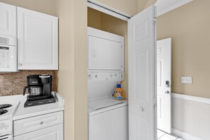 A laundry room with a washing machine, dryer, and a coffee maker.