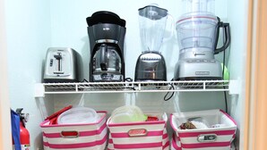 A kitchen with a toaster, coffee maker, blender, and various storage bins. - Oceanfront condo with beach view – 2 pools (Galveston)