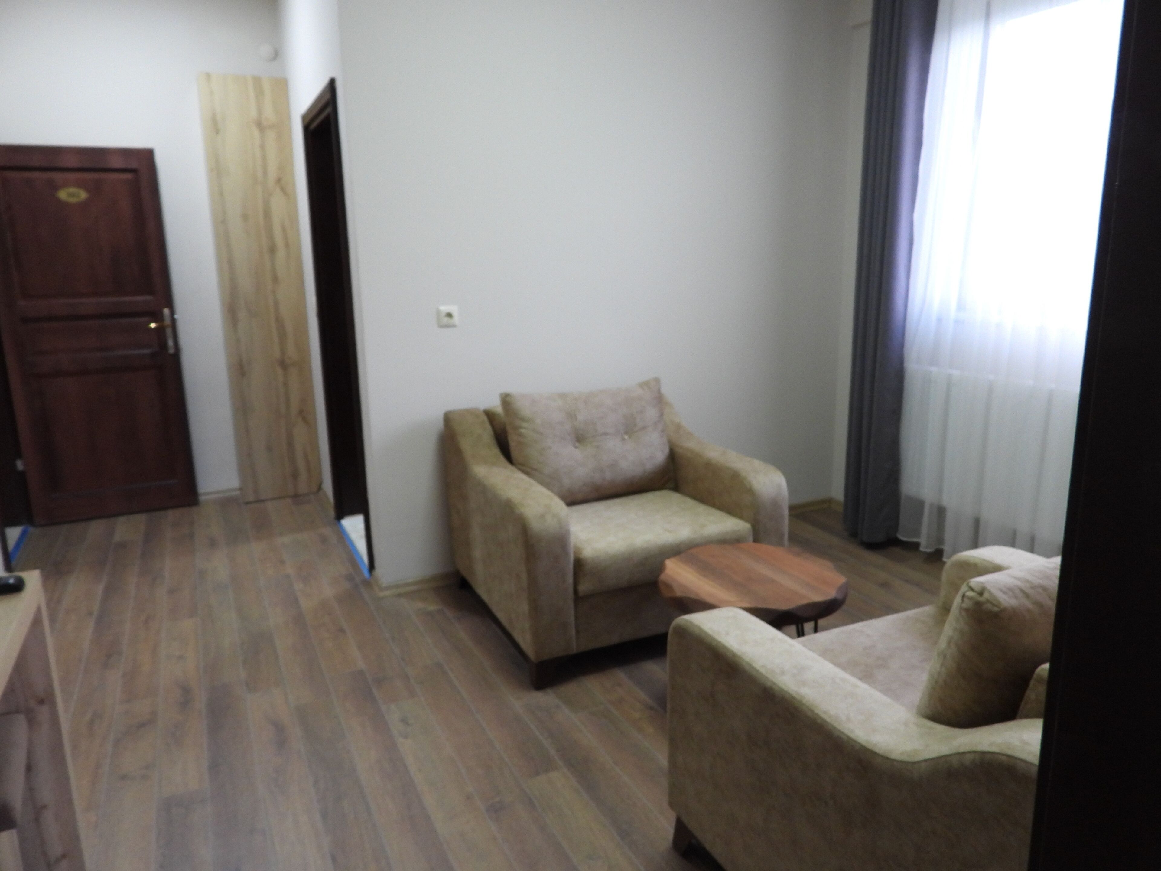 A living room with a sofa, a wooden coffee table, and a door.