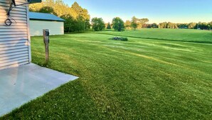 A well-maintained lawn with a small shed and a wooden post. - NEW!! Clean, Comfortable & Spacious Northwoods Cabin. (Florence)