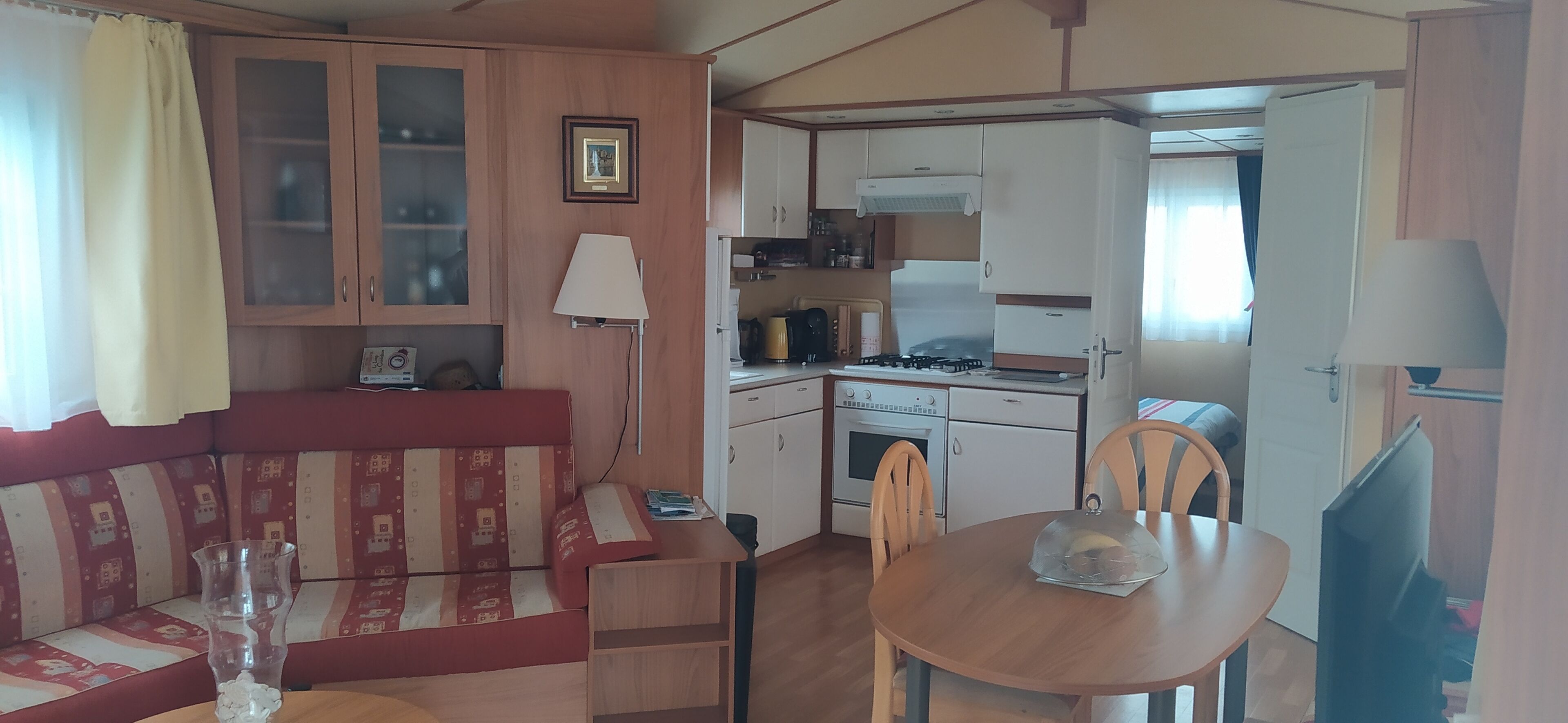 A compact living space with a kitchenette, a dining area, and a seating area with a sofa and table.