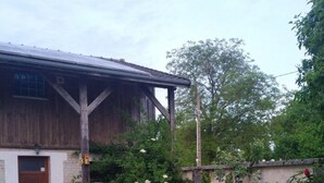 Ein rustikales Holzhaus mit Backsteinportal und einer kleinen Terrasse.