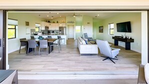 A modern open-plan living area with a kitchen, dining space, and seating area. - Spectacular beach front views with a short walk to members only beach (Upper Captiva)