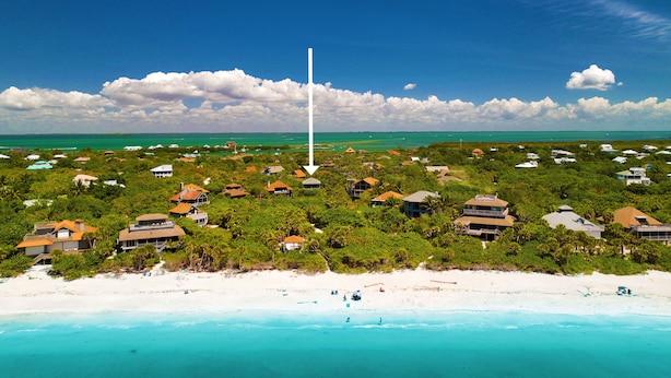 A coastal resort with beachfront properties, lush greenery, and a clear view of the ocean. - Spectacular beach front views with a short walk to members only beach (Upper Captiva)