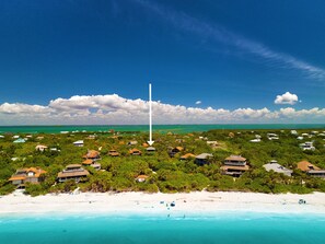 A coastal resort with beachfront properties, a clear sky, and a distant view of the ocean. - Spectacular beach front views with a short walk to members only beach (Upper Captiva)