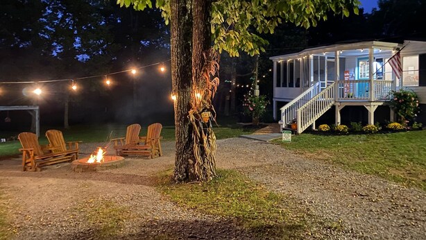 A house with a porch, outdoor seating, and a fire pit.
