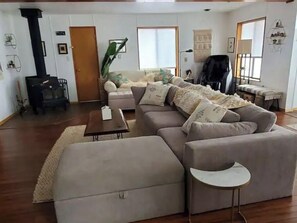 Una sala de estar con un sofá, una mesa de centro, una mesita auxiliar, una chimenea y una ventana.