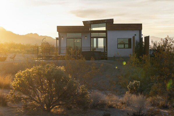 A modern two-story house with large windows and a patio area. - Panoramic Heaven - Luxury Property Pool & Spa (Joshua Tree)