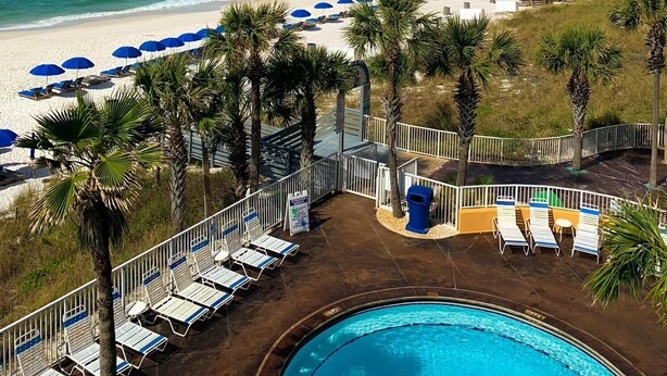 A poolside view with a beach and ocean in the background. - Low Floor, beautiful ocean views, seasonal beach chair service. No elevator wait (Panama City Beach)