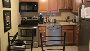 A kitchen with wooden cabinets, a microwave, stove, dishwasher, and a refrigerator. - 2BR/BA Silver Creek, Ski-in/out, Indoor/Outdoor Pool & Hot Tub (Snowshoe)