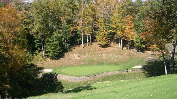 A golf course with a well-maintained green, sand bunkers, and a wooded backdrop. - 2BR/BA Silver Creek, Ski-in/out, Indoor/Outdoor Pool & Hot Tub (Snowshoe)