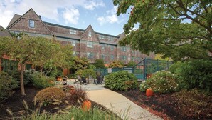 A courtyard with a brick building, outdoor seating, and a variety of plants. - Week of July 4!  Beautiful 2 bedroom unit in downtown Newport, RI  (Newport)