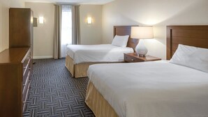 A hotel room with two beds, a dresser, a lamp, and a window with curtains. - Week of July 4!  Beautiful 2 bedroom unit in downtown Newport, RI  (Newport)