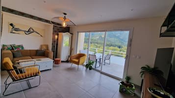 Un salon moderne comprenant un canapé, un fauteuil et un coin repas avec une table et des chaises.
