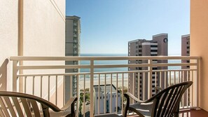 Enjoy ocean views from this balcony with a clear view of the surrounding buildings.