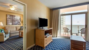 Relax in this stylish room with a flat-screen TV, comfortable sofa, and sliding glass door leading to a balcony with ocean views.