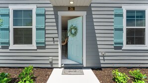 A house with a light blue door, a number '74' above the door, and a wreath hanging on the door. - *New Construction Luxury Townhome 3mi to downtown* (saint augustine)
