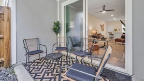 A patio with outdoor seating, a patterned floor, and a view into the interior. - *New Construction Luxury Townhome 3mi to downtown* (saint augustine)