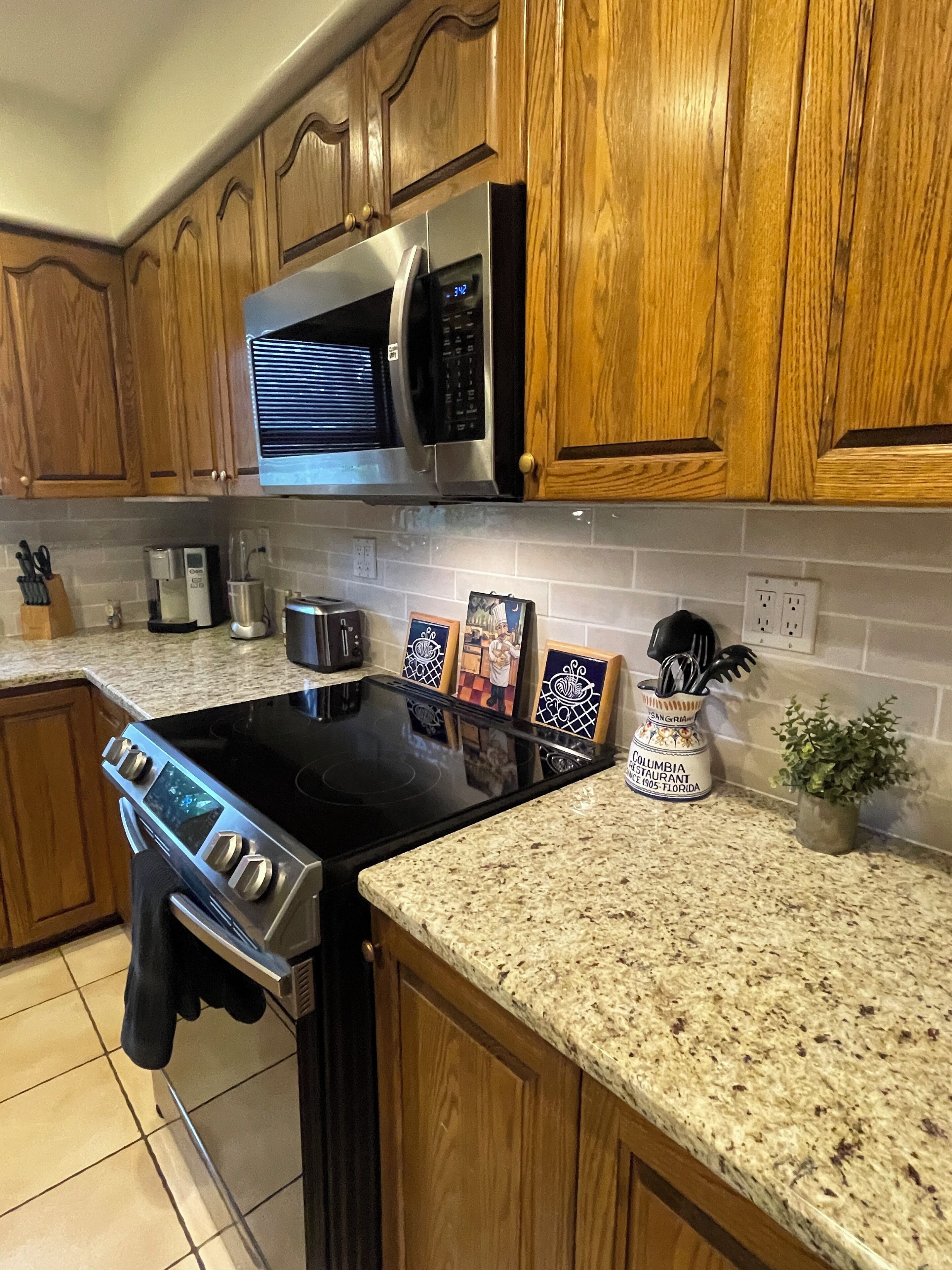 A kitchen with wooden cabinets, stainless steel appliances, a granite countertop, and a coffee maker.