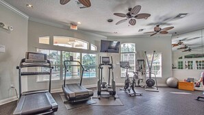 A gym with treadmills, elliptical machines, and free weights.