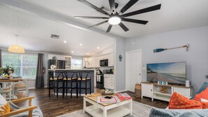 A modern living room with a dining area, kitchen, and a ceiling fan. - NEW!The Hideaway~Pool~Pickleball~Putt-Putt~Kayaks! (Marathon)