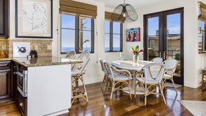 A kitchen with a central island, dining chairs, and a dining table.
