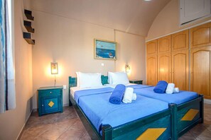 A hotel room with two beds, a painting on the wall, and wooden cabinets.