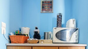 Un plan de travail de cuisine avec un four à micro-ondes, un grille-pain et divers ustensiles de cuisine.