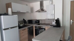 A modern kitchen with a built-in oven, a coffee machine, and a toaster. - Apartment T2 ANGLET (Anglet)