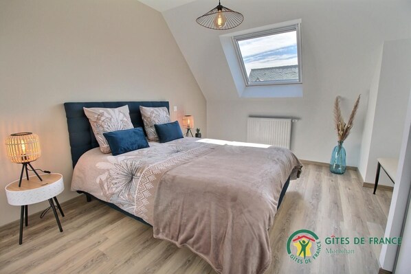 A bedroom with a bed, bedside lamps, a window, and a radiator.