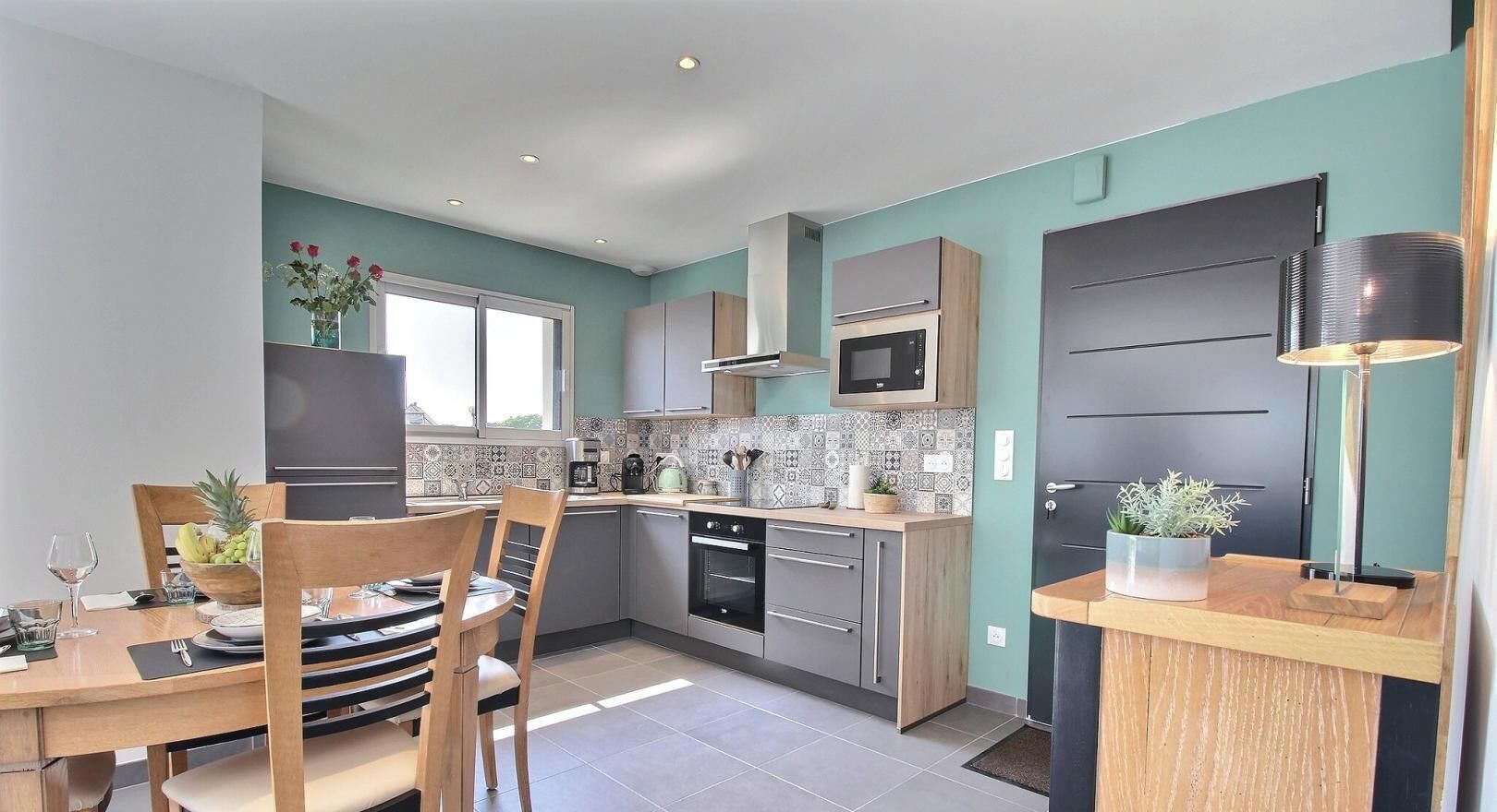 A modern kitchen with a dining area, featuring a microwave, oven, and a variety of cabinets.