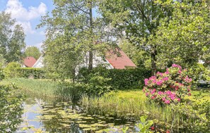 Surrounded by lush greenery and flowering plants, this serene water body offers a peaceful escape.