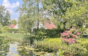 Surrounded by lush greenery and flowering plants, this serene water body offers a peaceful escape.