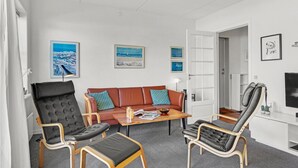 A modern living room with a sofa, two armchairs, a coffee table, and artwork on the walls. - Cozy apartment in Rudkøbing (Rudkøbing)