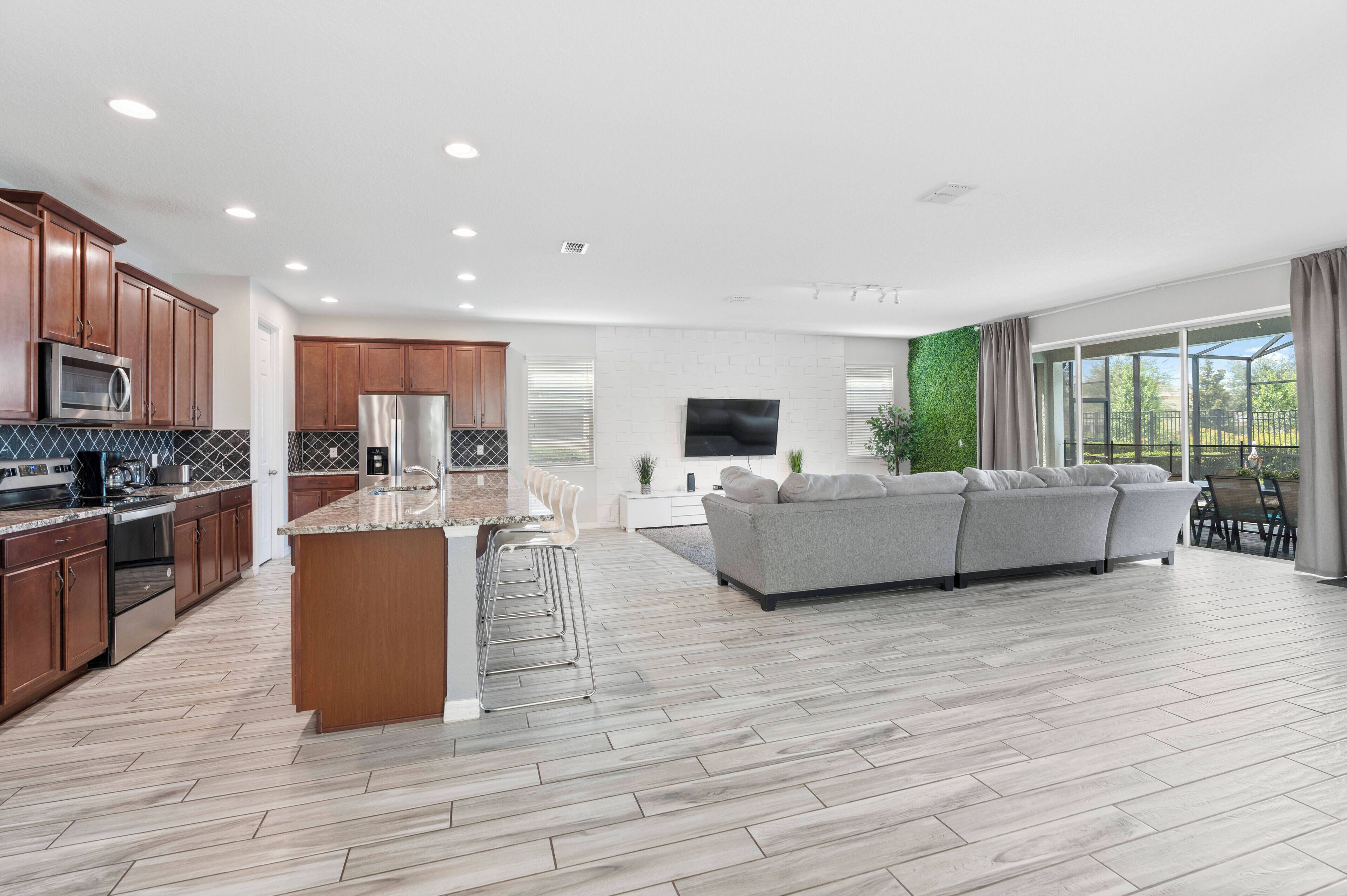 A modern kitchen with wooden cabinets, stainless steel appliances, and a central island.