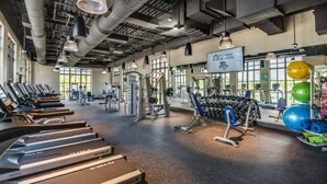 A gym with treadmills, weight machines, and exercise balls. - 9BR house with private pool in Solara Resort (Kissimmee)