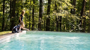 A swimming pool with two people sitting on the edge.