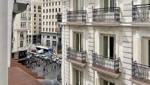 Un immeuble à plusieurs étages, doté de balcons décorés et de grandes fenêtres.